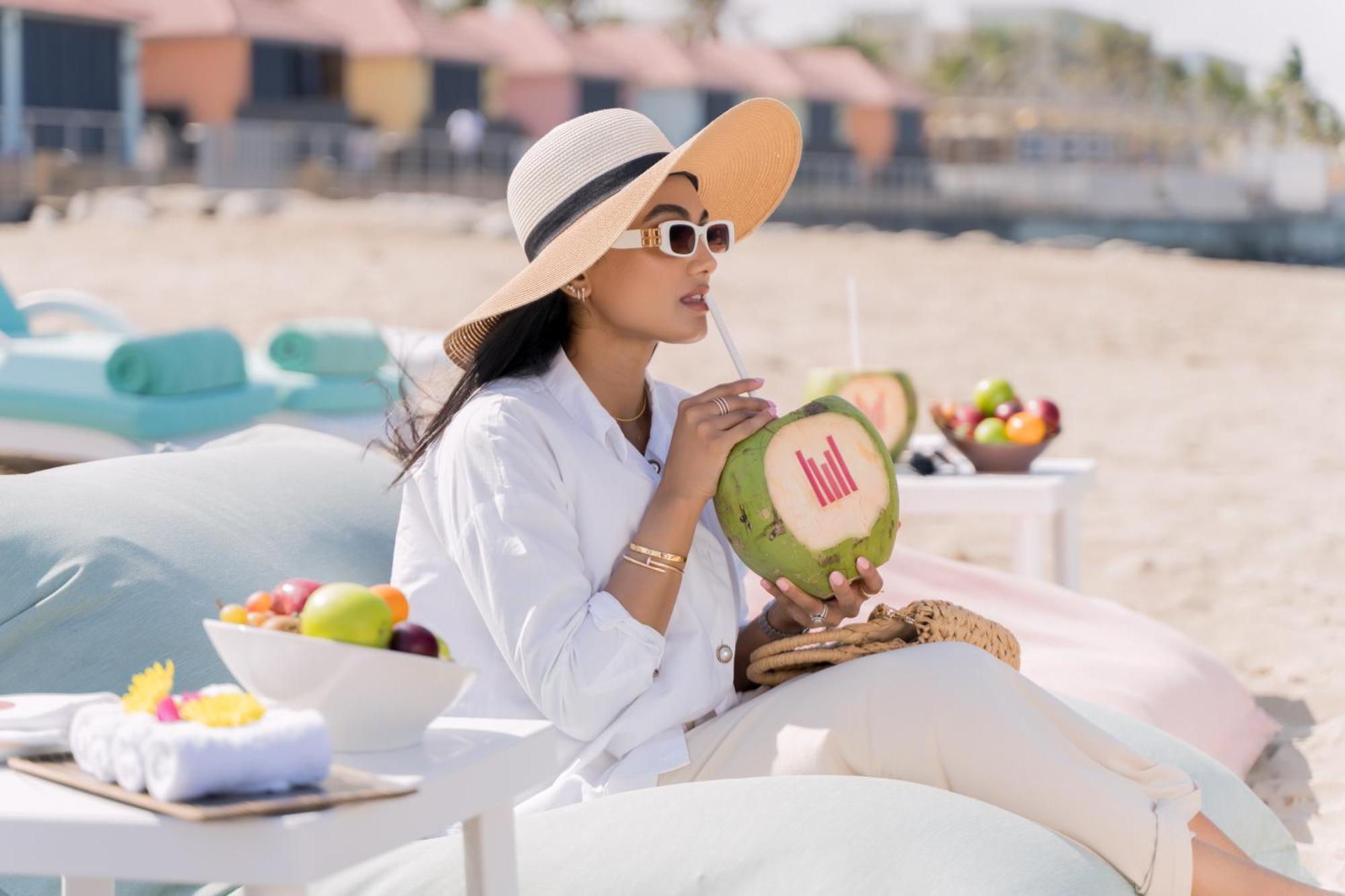 Hotel Grand Millennium Maskat Zewnętrze zdjęcie A woman drinking from a coconut